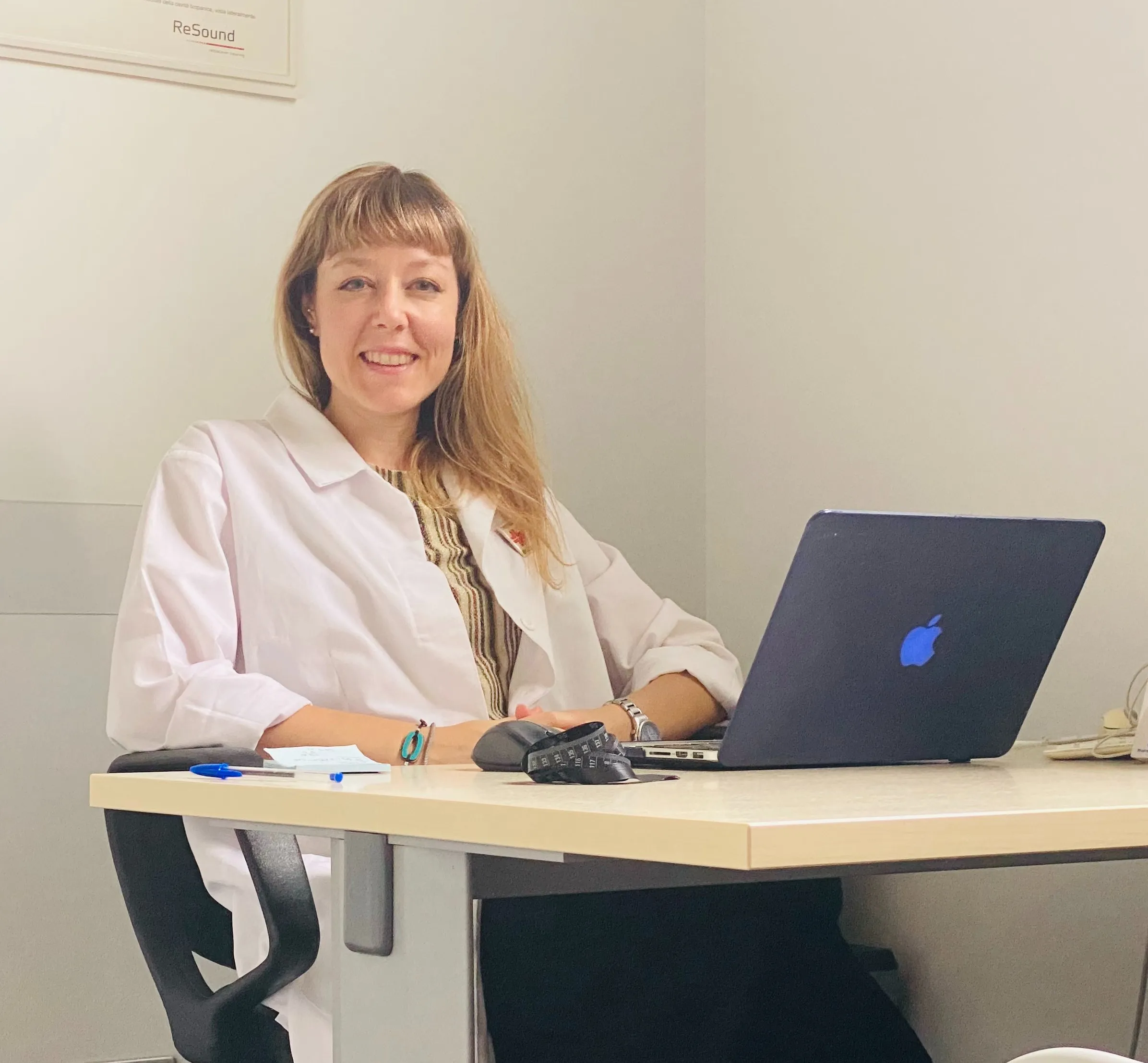 Elisa Colombo, biologa nutrizionista, sorridente alla scrivania del suo studio